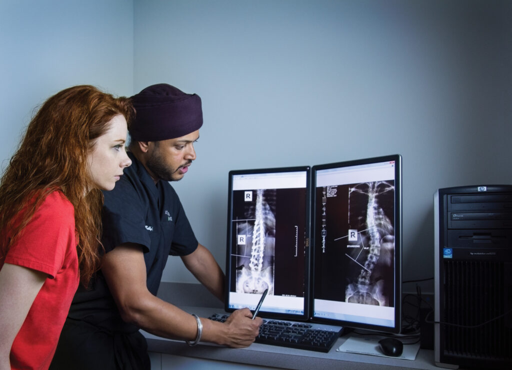 Orthopedic surgeons analyzing diagnostic spinal X-rays for surgical intervention planning